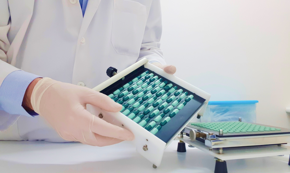 Pharmacist showing blister packaging machine