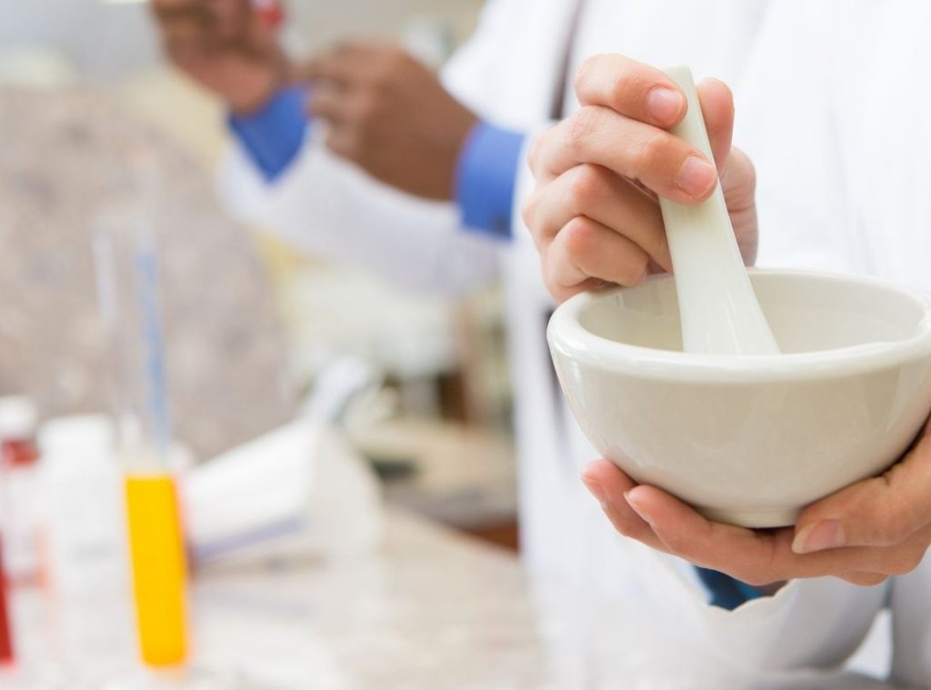 Pharmacist holding mortar and pestle for compound making