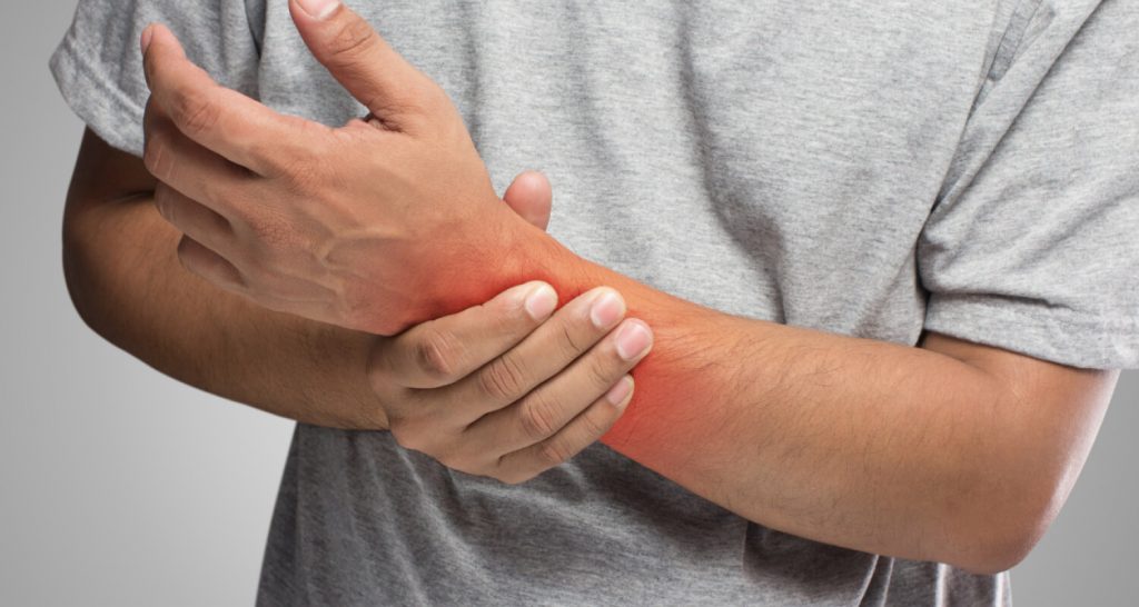 Man Holding Wrist In Pain
