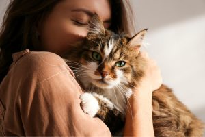 Woman hugging pet cat