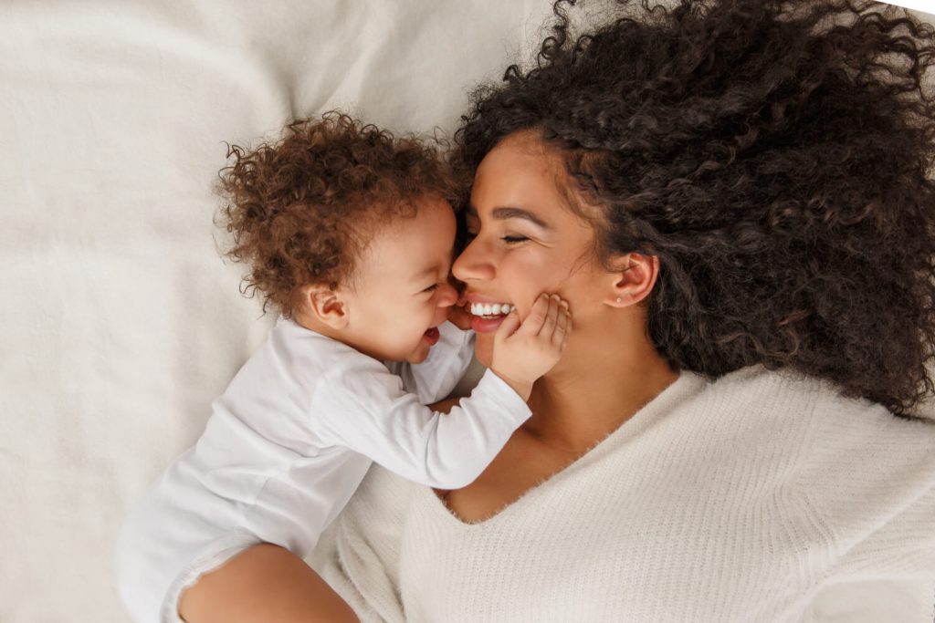 Woman laying on bed with her baby