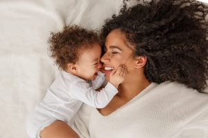 Woman laying on bed with her baby